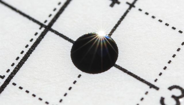 Macro answer bubble reflecting starburst highlight on optical mark exam sheet