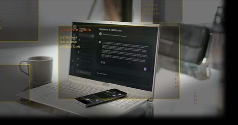 Silver laptop running dark crm with smartphone and yellow ar overlays on minimalist desk