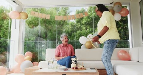 Multiracial Senior Lesbian Couple Celebrating Birthday at Home