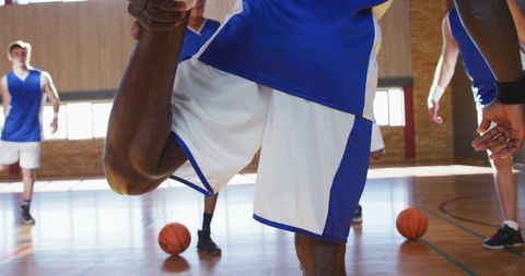Diverse Basketball Team Stretching on Indoor Court in Blue Uniforms - Download Free Stock Images Pikwizard.com