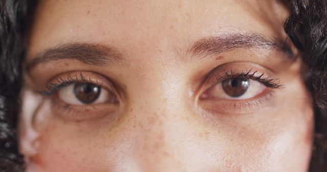 This image captures a close-up view of a woman's face, focusing on her eyes, eyebrows, and freckles. Use this for beauty and skincare articles, natural beauty campaigns, and promotional material for cosmetics emphasizing authenticity and natural look.