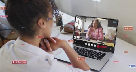Young woman joining remote video call on laptop with smiling presenter in bright workspace