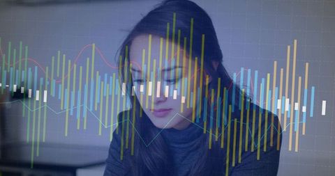 Asian Businesswoman Studying Financial Graphs in Modern Office