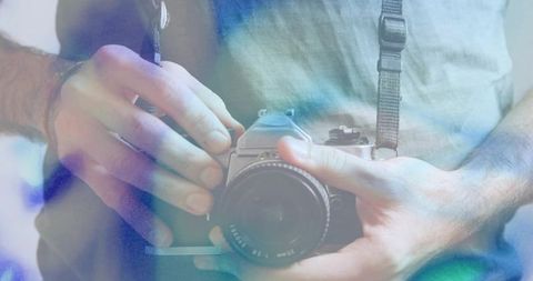 Holding Vintage SLR Camera with Soft-Focus Bokeh, Analog Lens, Casual Wristband