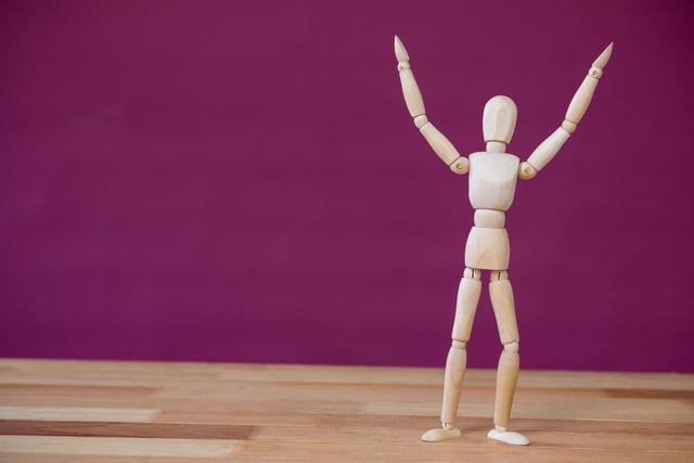 Figurine standing with arms stretched on a wooden floor - Download Free Stock Photos Pikwizard.com