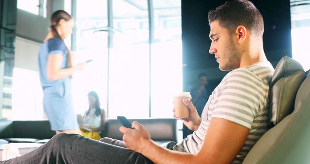 Man Relaxing with Coffee and Smartphone in Modern Office Lounge - Download Free Stock Images Pikwizard.com