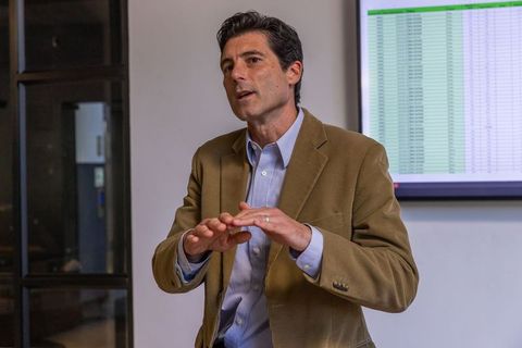 Business professional presenting data in meeting with spreadsheet