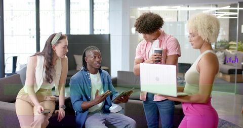Diverse team collaborating and analyzing venn diagram data on laptop in modern office