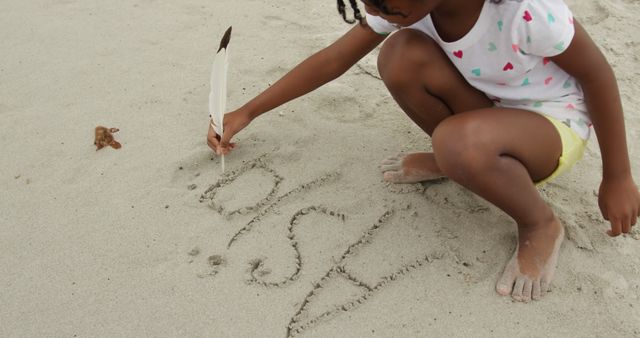 Little Girl Drawing with Feather on Sandy Beach - Download Free Stock Images Pikwizard.com