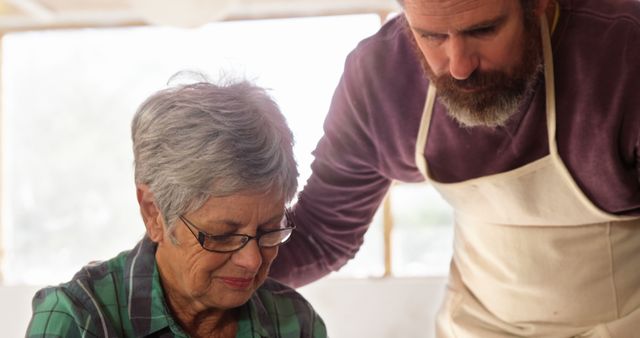 Elderly Woman Learning Pottery from Bearded Instructor in Studio - Download Free Stock Images Pikwizard.com