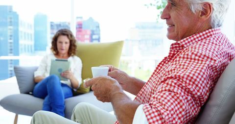 Relaxed Mature Man Sipping Coffee at Home in Bright Living Room