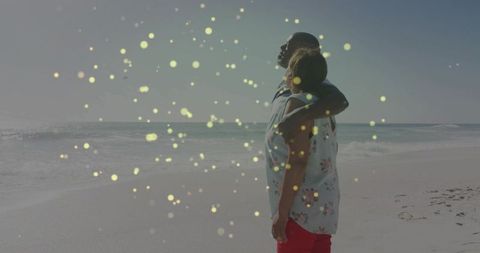 Couple embracing at ocean shoreline with dreamy bokeh lights, seeking calm and romance