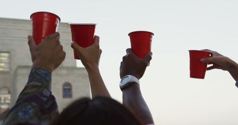 Diverse Friends Toasting Red Cups in Rooftop Party