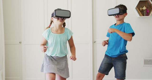 Caucasian brother and sister gesturing while wearing vr headset at home. entertainment and gaming technology concept