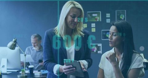 Businesswomen Collaborating on Tablet Reviewing Data Visualizations, Analytics in Office