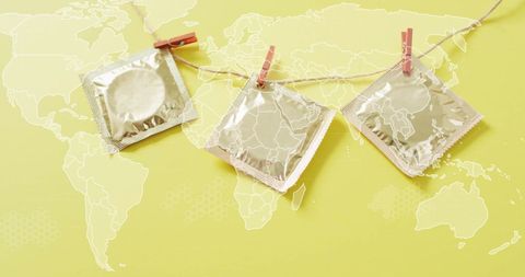 Condoms on clothesline over world map illustrate global sexual health awareness
