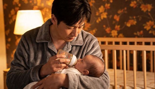 Father feeding newborn bottle in cozy nursery nighttime bonding gentle caregiving