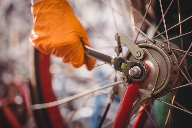 Close-up of mechanic repairing a bicycle in workshop