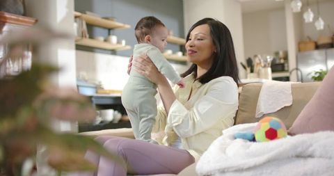 Mother Cradling Baby Girl in Stylish Open-Plan Kitchen