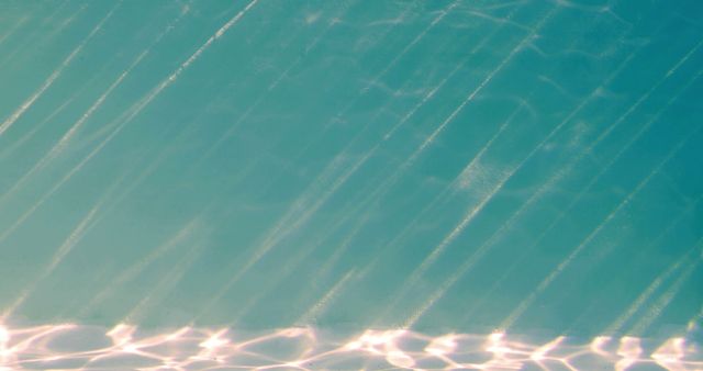 Sunlight filtering through water creates beautiful abstract light patterns. This image can be used for backgrounds, nature themes, and pool-related materials.