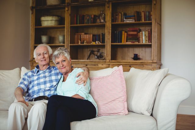 Portrait of senior couple relaxing on sofa in living room at home