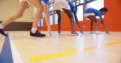 Diverse Female Athletes Sprinting in School Gym