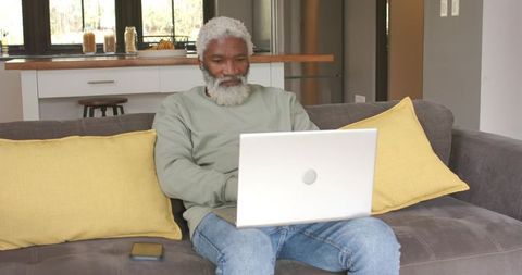 Senior African American Man Using Laptop at Home for Remote Work