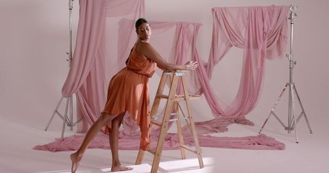 Elegant Model Posing in Fashion Studio with Pink Fabrics