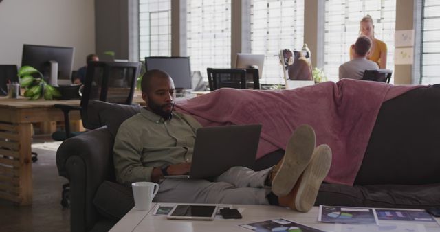 Relaxed Professional Working on Sofa in Modern Office - Download Free Stock Images Pikwizard.com