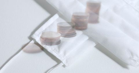 Face Masks and Coins Pile Reflecting Covid-19 Economic Impact