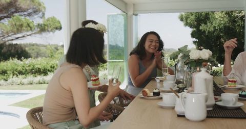 Women Enjoying Afternoon Tea and Desserts Together Outdoors