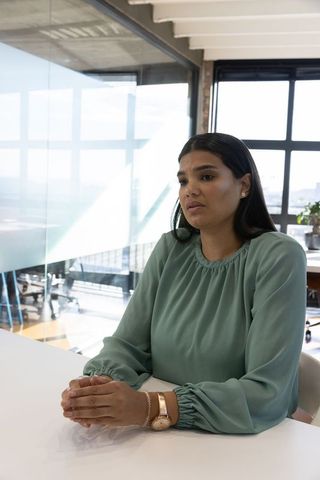 Woman Sitting at Conference Table Relaxed Corporate Environment