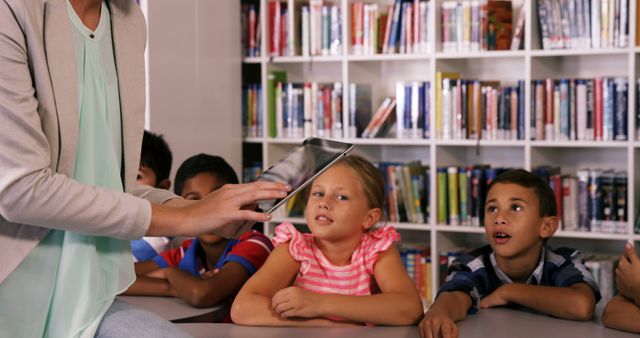 Teacher Using Tablet for Educational Activities with Engaged Children in Library - Download Free Stock Images Pikwizard.com