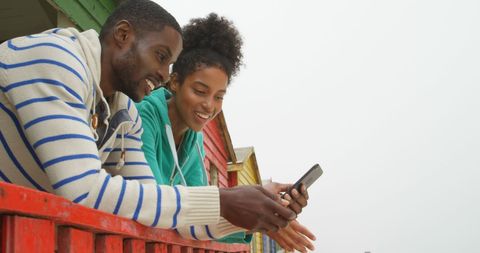 Smiling Friends Sharing Smartphone Joy Outdoors - Download Free Stock Images Pikwizard.com