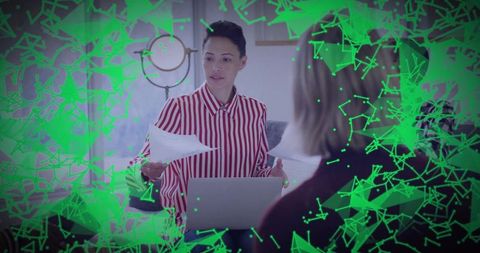 Presenting woman leading collaborative meeting with laptop and documents, green overlay