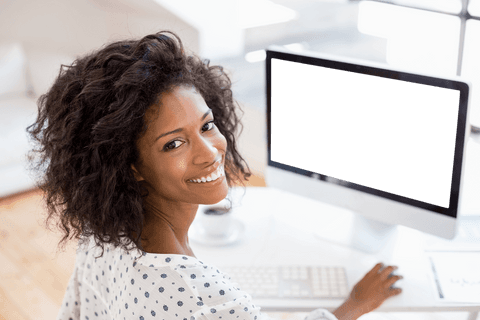 Transparent smiling woman at desk with desktop computer