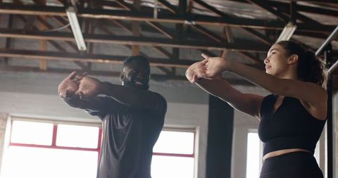 Diverse Workout Partners Stretching in Modern Gym