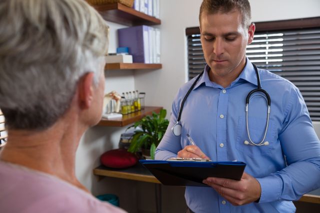 Physiotherapist writing a prescription on a clipboard for a senior patient in a clinic. Ideal for use in healthcare, medical, and elderly care contexts, showcasing patient care, medical consultations, and professional healthcare services.