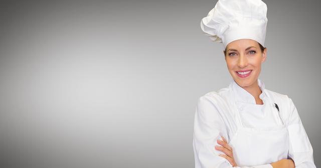 This image features a confident female chef standing with arms crossed, wearing a white uniform and chef hat, against a grey background. Ideal for use in culinary blogs, restaurant websites, cooking classes, and promotional materials for the food industry.