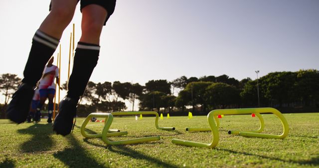 Legs of female football player exercising on sunny sports field - Download Free Stock Photos Pikwizard.com