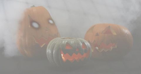 Moody foggy jack-o-lantern trio glowing with eerie gray-green pumpkin and soft backlight