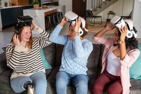 Diverse Friends Relaxing with VR Headsets in Living Room