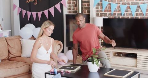 Friends preparing decorations for fun baby shower party