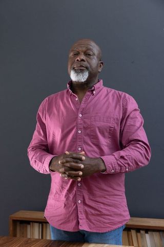 Portrait of senior african american man in casual pink shirt
