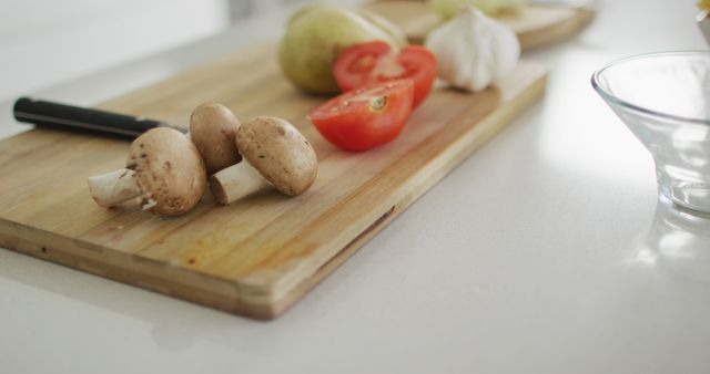 Vegetables and garlic on wooden chopping board in kitchen. wellbeing and domestic lifestyle, preparing healthy food at home.