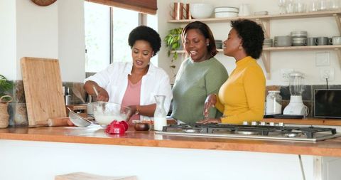 Female Friends Enjoying Cooking Together in Modern Kitchen