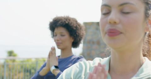 Practicing outdoor meditation on sunlit terrace with smartwatch and mindful breathing