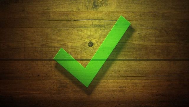 Green checkmark on rustic wooden background symbolizes approval and success