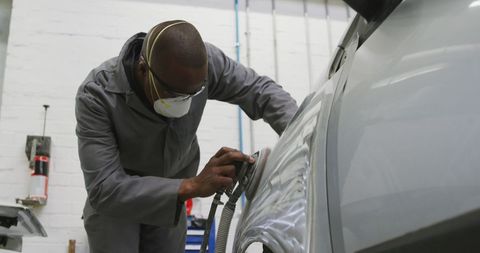 Mechanic Repairing Car Bodywork in Workshop with Face Mask - Download Free Stock Images Pikwizard.com
