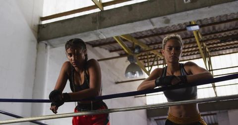 Two Female Boxers Taking a Break in Industrial Gym